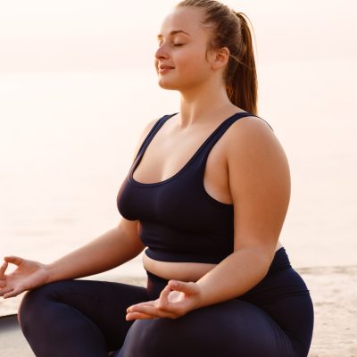 Ginger young woman meditating during yoga practice outdoors